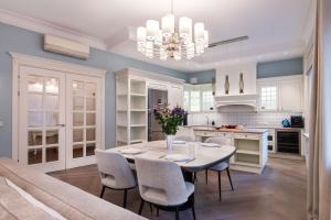 a dining room and kitchen with a table and chairs at Luxury 2BDR Heart Of Old Town in Vilnius