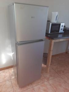 un réfrigérateur dans une cuisine à côté d'un four micro-ondes dans l'établissement OrbanLife Lite Keetmanshoop, à Keetmanshoop