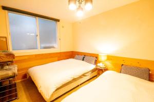 a bedroom with two beds and a window at kODATEL コダテル 札幌大通公園 101 in Sapporo