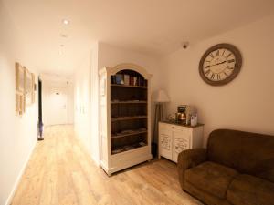 a living room with a clock on the wall and a couch at Casa Nicolasa in Donostia-San Sebastián +25 photos