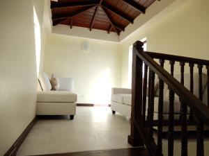 a living room with a staircase and a couch at Oistins Bayview Apartments in Christ Church