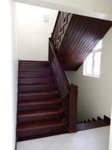 a staircase in a house with wooden railings at Oistins Bayview Apartments in Christ Church