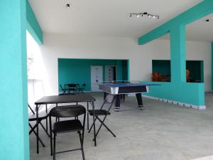 a room with two tables and a ping pong table at Oistins Bayview Apartments in Christ Church