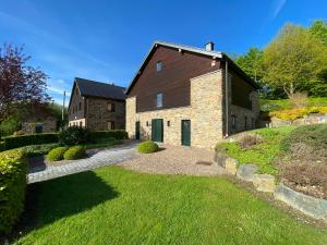 una gran casa de ladrillo con una puerta verde en Gite Du Moulin Coquelicot, en Stavelot