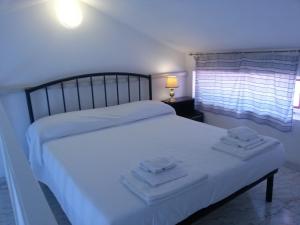 1 dormitorio con 1 cama blanca y 2 toallas en Camere Da Aldo in centro Sirolo, en Sirolo