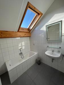 a bathroom with a bath tub and a sink at Gite Du Moulin Coquelicot in Stavelot