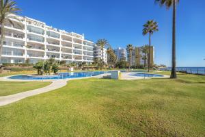 a large apartment building with a swimming pool and palm trees at Apartamento Mi Capricho in Mijas Costa