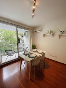 een eetkamer met een tafel en een groot raam bij Mansilla Apartment in Buenos Aires