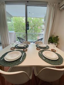 a dining room table with chairs and plates and a window at Mansilla Apartment in Buenos Aires