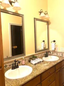 een badkamer met 2 wastafels en 2 spiegels bij Private Master suite with Sauna and Bathtub in Fair Oaks