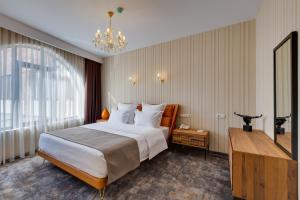 a hotel room with a large bed and a chandelier at Mukhrantubani Boutique Hotel in Tbilisi City