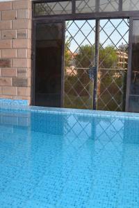 a large blue swimming pool with a fence around it at ASWAN NILE PALACE (swimming pool-rooftop-Nile view) in Aswan