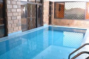 a blue swimming pool with a fence around it at ASWAN NILE PALACE (swimming pool-rooftop-Nile view) in Aswan