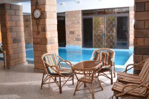 a group of chairs and a table in front of a pool at ASWAN NILE PALACE (swimming pool-rooftop-Nile view) in Aswan