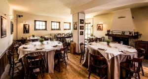 a dining room with tables with white tablecloths at Ostello del Quadrifoglio in Ameno