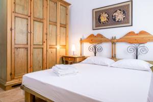 a bedroom with a white bed with a wooden headboard at Villa Pinewood in Santa Margherita di Pula +131 photos