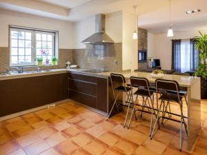 a kitchen with a large island with bar stools at Cerca dos Passais in Entre Ambos os Rios