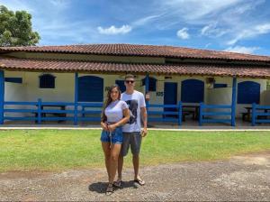 a man and a woman standing in front of a building at Tijota Hotel Fazenda in Ipatinga