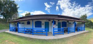 a small blue and white building with a roof at Tijota Hotel Fazenda in Ipatinga