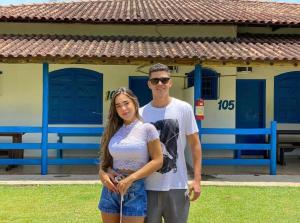 a man and a woman standing in front of a house at Tijota Hotel Fazenda in Ipatinga