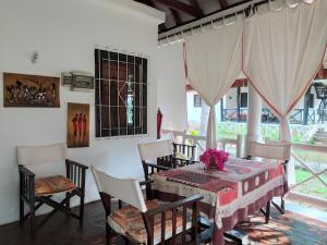 a dining room with a table and chairs and a window at Villa 36 Karibuni in Malindi