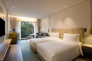 a hotel room with two beds and a table at Radisson Blu Mumbai International Airport in Mumbai