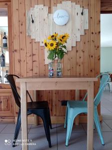 uma mesa e duas cadeiras com um vaso de flores em Fior di Roccia - Valmalenco - Hotel & Mountain Restaurant em Lanzada