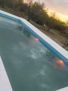a swimming pool with a reflection in the water at Luna de los Molles in Villa Las Rosas