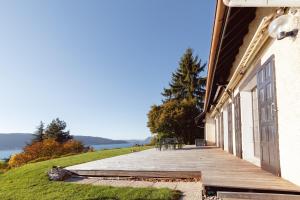 een houten veranda in een gebouw met uitzicht op het water bij Villa Montpellaz in Veyrier-du-Lac