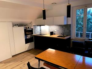 a kitchen with a wooden table and a dining room at Elégant 3 pièces - Parking in Thonon-les-Bains