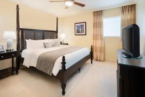 a bedroom with a bed and a flat screen tv at O2 Beach Club & Spa All Inclusive by Ocean Hotels in Christ Church