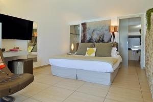 a bedroom with a large bed and a couch at L'Escale Côté Sud in LʼÎle-Rousse