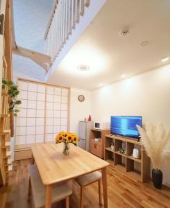 a living room with a table and a tv at Opopo home 堺町店 in Otaru