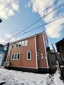 a red brick building in the snow at Opopo home 堺町店 in Otaru