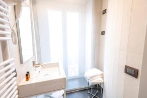 un bagno bianco con lavandino e finestra di B&B il Divino a Napoli