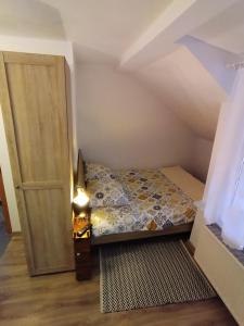 a small bedroom with a bed next to a door at Pokój w Karpaczu in Karpacz