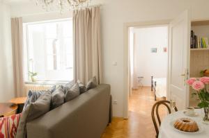 a living room with a couch and a table at Wishlist Prague Residences - Charles Bridge Karlova in Prague