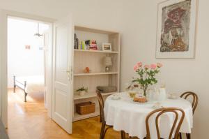 a table with a white table cloth and flowers on it at Wishlist Prague Residences - Charles Bridge Karlova in Prague