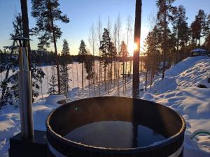 una bañera de hidromasaje en la nieve con puesta de sol en Tahko Hills, en Tahkovuori