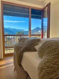 a bedroom with a bed and a large window with a view at Künstlervilla mit grandiosem Panoramablick in Fischbachau