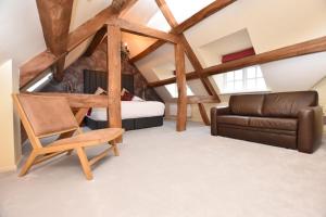 een slaapkamer met een bed, een stoel en een bank bij The Halford Bridge Inn in Shipston on Stour