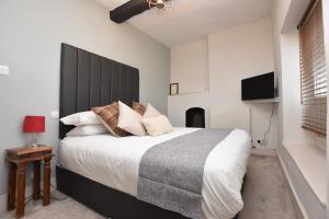 sypialnia z dużym łóżkiem z czarnym zagłówkiem w obiekcie The Halford Bridge Inn w mieście Shipston-on-Stour