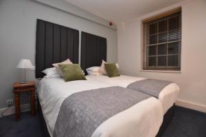 two beds sitting next to each other in a room at The Halford Bridge Inn in Shipston-on-Stour