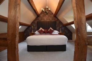 una camera da letto con un grande letto in mansarda di The Halford Bridge Inn a Shipston-on-Stour