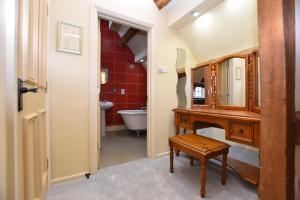 uma casa de banho com um lavatório de madeira e um espelho em The Halford Bridge Inn em Shipston on Stour
