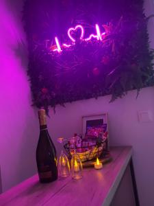 a bottle of wine sitting on a table with a pink light at L’appart[é] BLACK superbe appartement pop ! in Besançon +11 photos