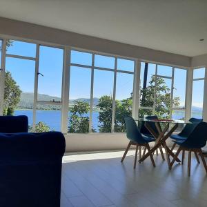 Manz' amahle Guest Cottage في هارتبيسبورت: غرفة معيشة مع طاولة وكراسي ونوافذ +4 صور