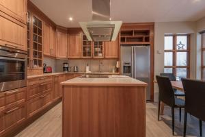 a kitchen with wooden cabinets and a island with a sink at Margrétarhof in Hella