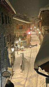 une rue enneigée la nuit avec un bâtiment dans l'établissement Apartamento turístico Nievesol 24 - Benasque, à Benasque