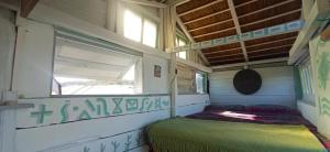 Una cama en una habitación pequeña con ventana. en Casa Candombe y Mar, en Barra de Valizas